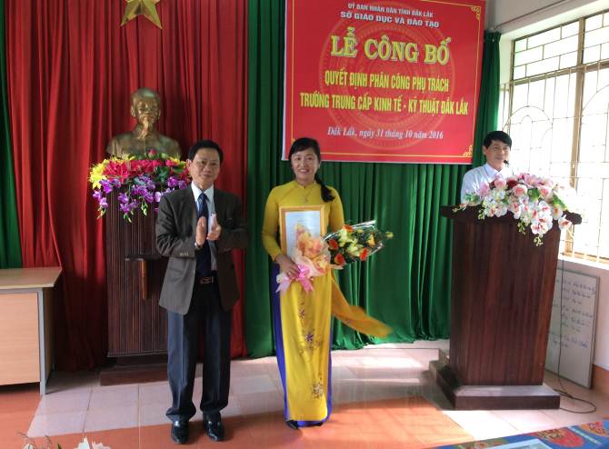 Ông Bùi Hữu Thành Cát- Phó Giám đốc Sở GDĐT trao Quyết định và tặng hoa cho bà Trần Thị Minh Lý