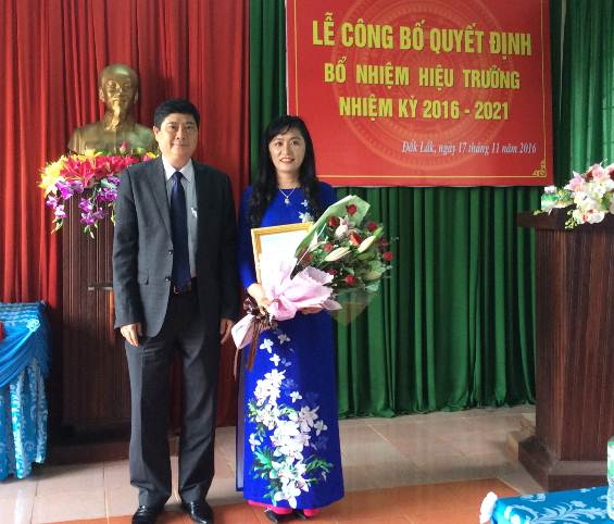 Ông Phạm Đăng Khoa- Giám đốc Sở GDĐT trao Quyết định và tặng hoa cho bà Trần Thị Minh Lý