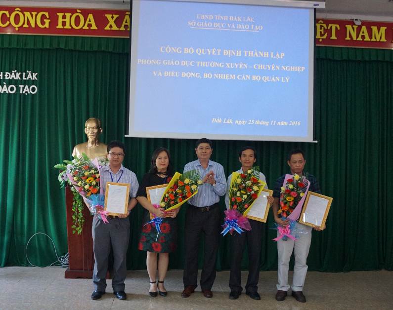 Ông Phạm Đăng Khoa- Giám đốc Sở GDĐT trao Quyết định và tặng hoa cho các ông bà được điều động, bổ nhiệm vào các chức vụ mới