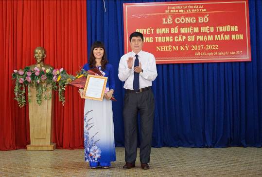 Ông Phạm Đăng Khoa- Giám đốc Sở GDĐT trao Quyết định và tặng hoa cho bà Vũ Thị Thanh Hiển